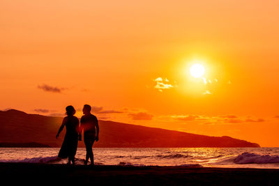 Silhouette of two persons in sunset, love and dancing, having fun.