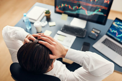 Worried businessman looking at charts stressed by news from stock market. investor lost money online