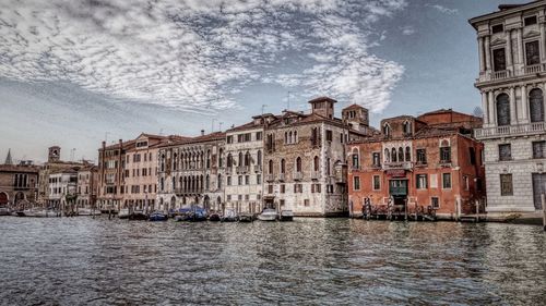 Buildings in city against cloudy sky