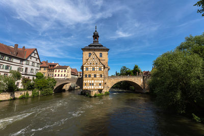 Arch bridge over river against buildings