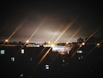 Illuminated cityscape against sky at night