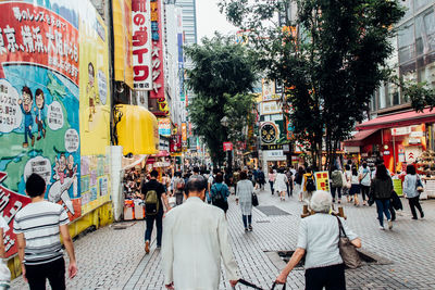 People on street amidst buildings in city