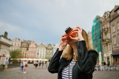 Female traveler taking picture with vintage instant camera