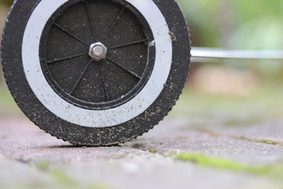 Close-up of old wheel against wall