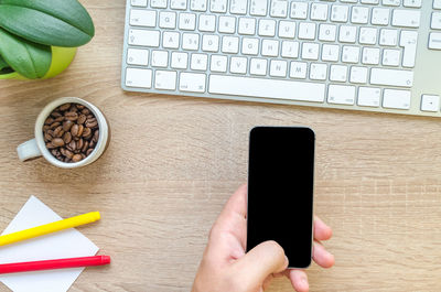 Midsection of person using smart phone on table