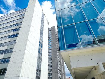 Low angle view of modern buildings against blue sky