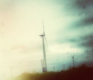 Low angle view of windmills against sky