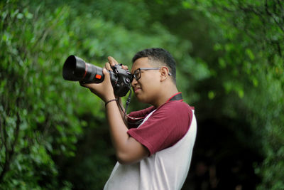 Side view of a boy photographing