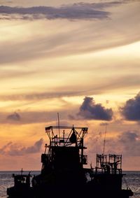 Silhouette ship on sea against sky during sunset