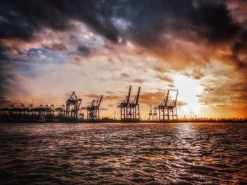 Pier over sea against sky during sunset