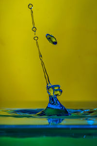 Close-up of drop falling on blue water