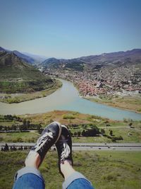 Low section of man on river against clear sky