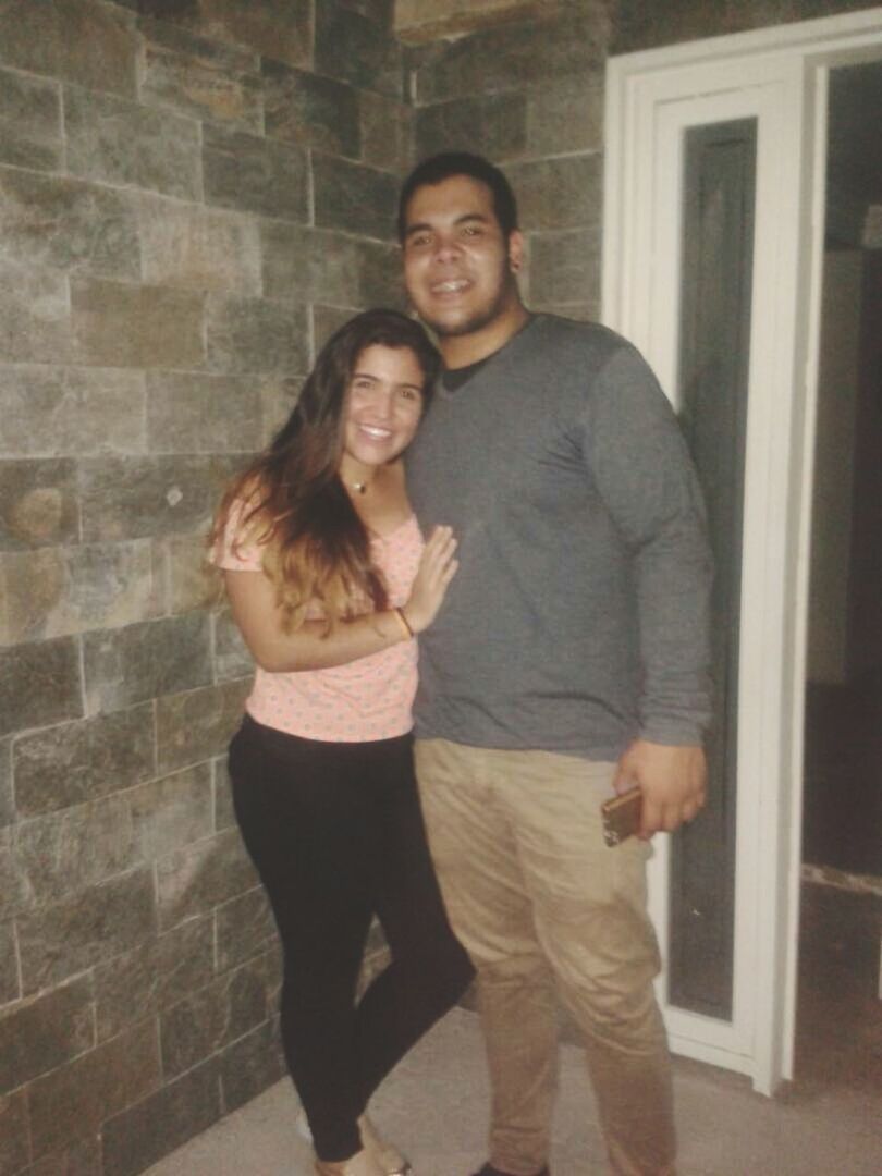 PORTRAIT OF A SMILING YOUNG COUPLE STANDING OUTDOORS