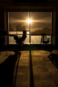 Silhouette man in illuminated room