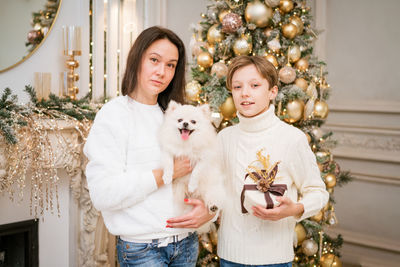Happy caucasian family mother and son sitting at home near christmas tree