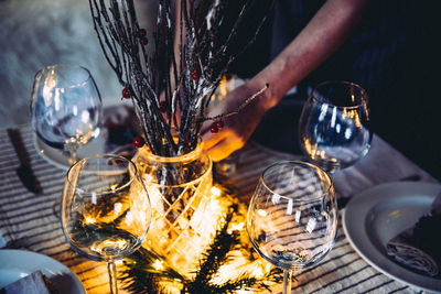 Cropped hands by decoration and wineglasses at table