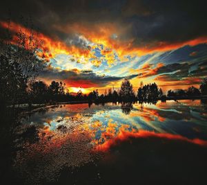 Scenic view of dramatic sky over lake during sunset