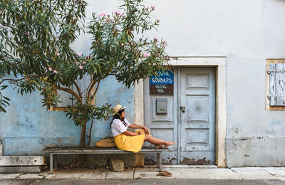 Woman sitting on chair outside building