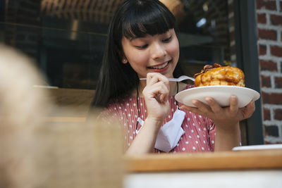 Portrait of a smiling young woman holding ice cream