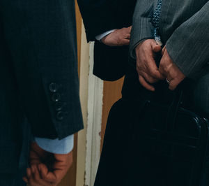 Midsection of businessmen standing in office