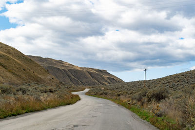 Road by mountain against sky