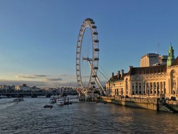 Ferris wheel in city against clear sky