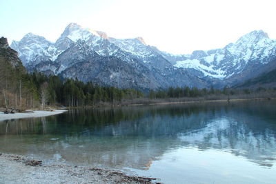 Scenic view of lake and snowcapped mountains against sky