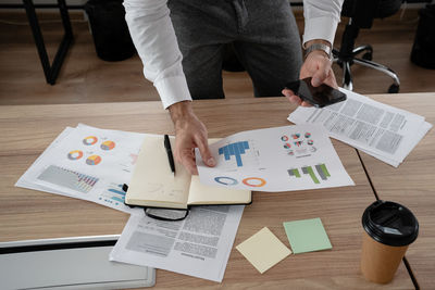 Midsection of business colleagues working on table