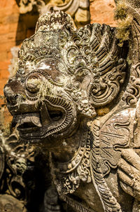 Close-up of buddha statue against old building