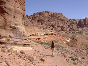 Rear view of woman walking in rocky landscape