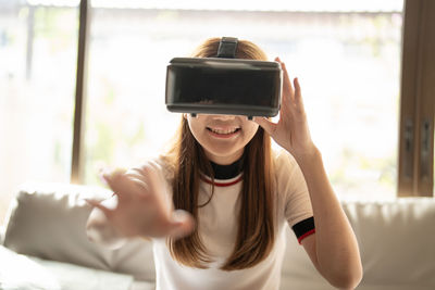 Smiling girl gesturing wearing virtual reality headset