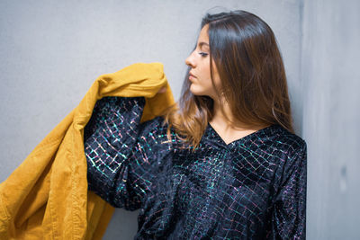 Close-up of young woman against wall