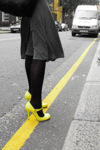 Low section of man walking on road