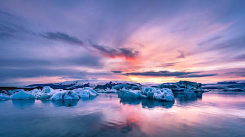 Scenic view of frozen lake against sky during sunset