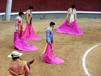 Group of people standing by pink umbrella