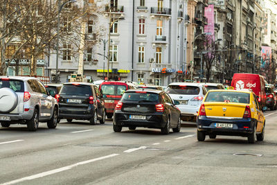 Vehicles on road amidst buildings in city