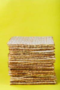 Close-up of stack on table against yellow background