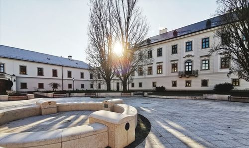 Street by buildings in city against sky