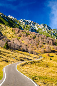 Road by mountain against blue sky