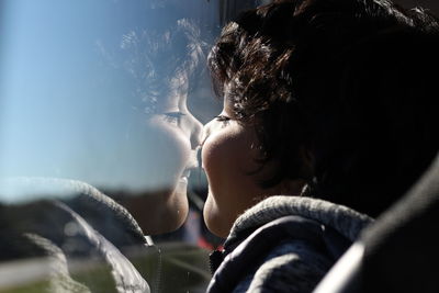 Close-up of boy with reflection on glass