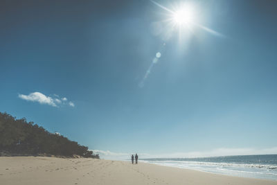 Scenic view of beach against sky on sunny day