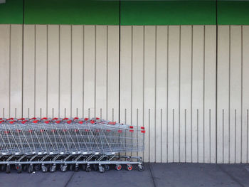 Row of shopping carts next to a wall