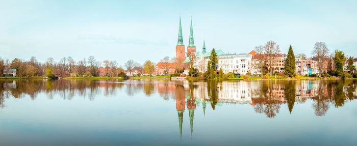 Scenic view of lake by buildings against sky