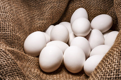 White chicken eggs on a burlap background
