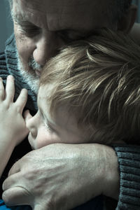 Close-up of grandfather embracing boy