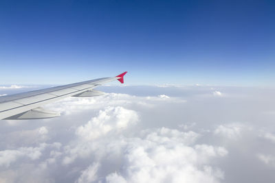 Airplane flying over cloudscape against sky