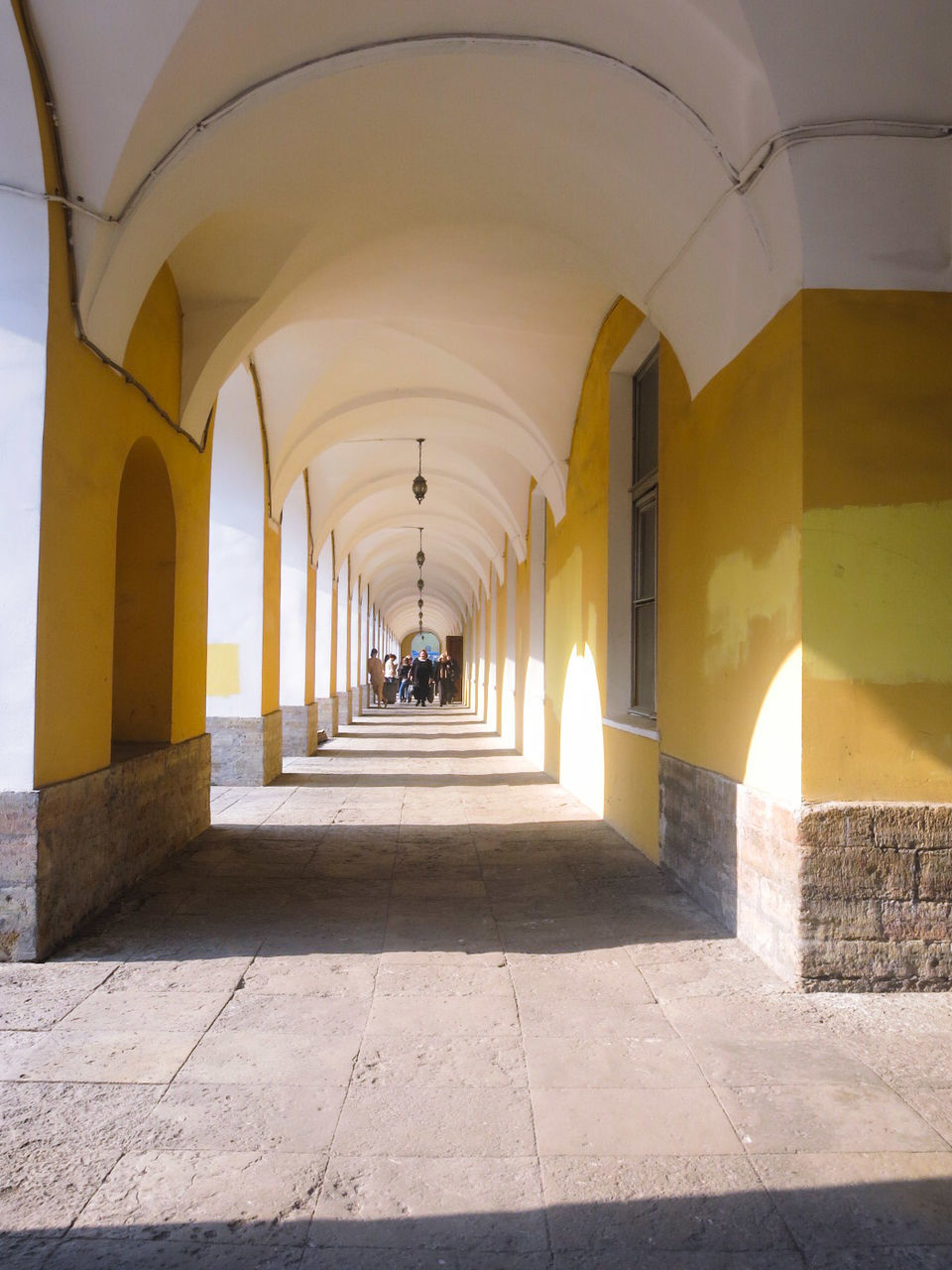 architecture, indoors, arch, the way forward, built structure, corridor, architectural column, ceiling, diminishing perspective, tiled floor, empty, column, vanishing point, in a row, flooring, illuminated, colonnade, building, archway, incidental people