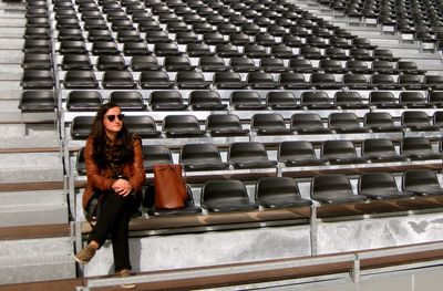 Woman sitting on bleachers at stadium