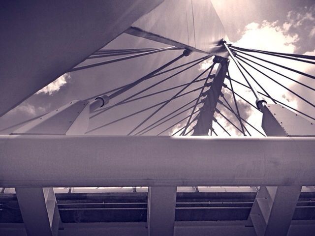 low angle view, built structure, architecture, sky, transportation, railing, connection, day, bridge - man made structure, no people, modern, outdoors, part of, engineering, sunlight, cloud - sky, cloud, mode of transport, metal, building exterior