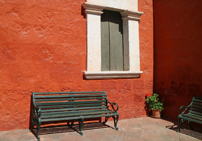 Empty bench against wall in building